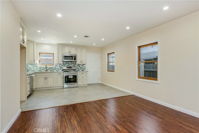 kitchen with a healthy amount of sunlight, light hardwood / wood-style floors, stainless steel appliances, and sink