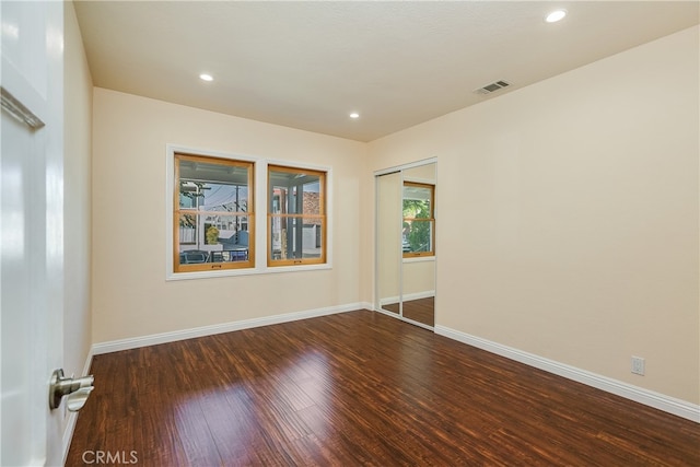 empty room with dark hardwood / wood-style flooring