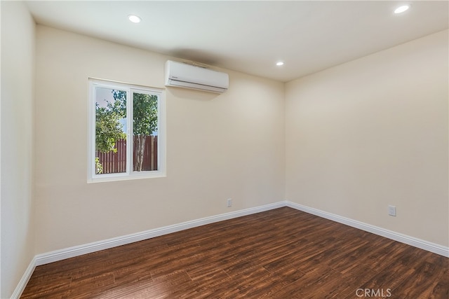 empty room featuring a wall mounted AC and dark wood-type flooring