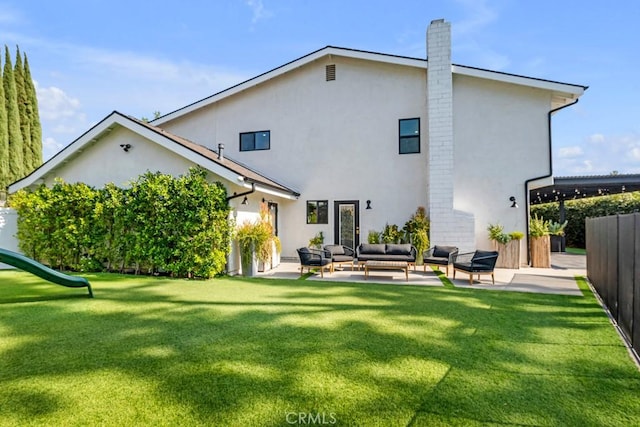 back of house with a playground, an outdoor living space, a patio area, and a yard