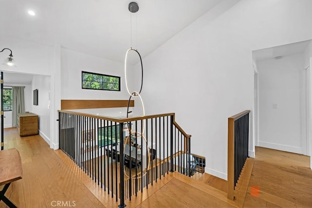 staircase with a towering ceiling and wood-type flooring