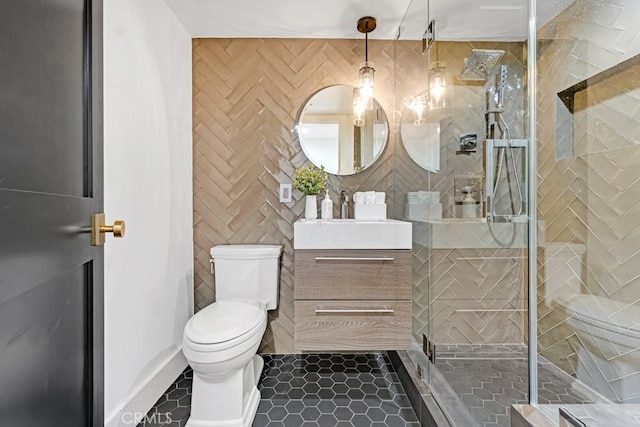 bathroom featuring tile patterned floors, vanity, toilet, and a shower with door