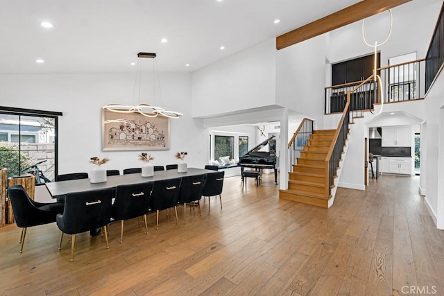 dining space featuring an inviting chandelier, light hardwood / wood-style flooring, high vaulted ceiling, and plenty of natural light