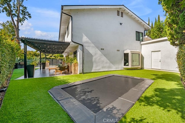 back of house with a pergola, a patio area, and a lawn