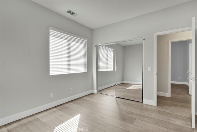 unfurnished bedroom featuring a closet and light hardwood / wood-style floors