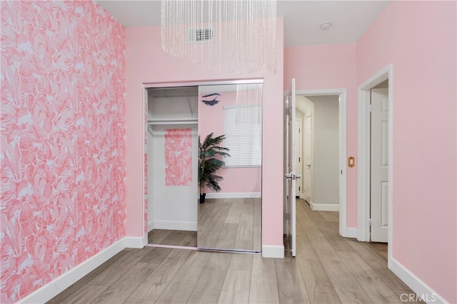 bedroom with light hardwood / wood-style flooring and a closet