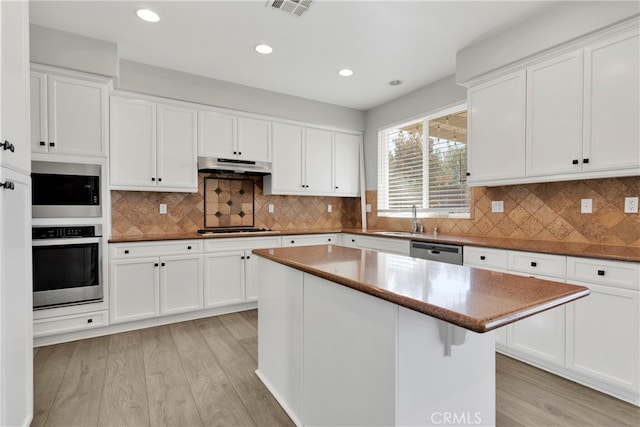 kitchen with light hardwood / wood-style floors, white cabinetry, and a center island