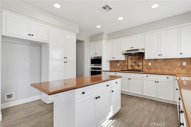 kitchen with light hardwood / wood-style flooring, white cabinetry, and a center island