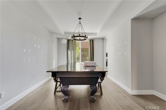 interior space featuring light hardwood / wood-style floors, an inviting chandelier, and a raised ceiling