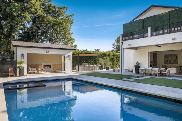 view of swimming pool with a patio area, an outdoor kitchen, and an outdoor hangout area