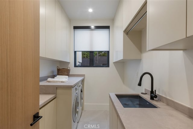 laundry area with light tile patterned flooring, cabinets, sink, and washer and clothes dryer