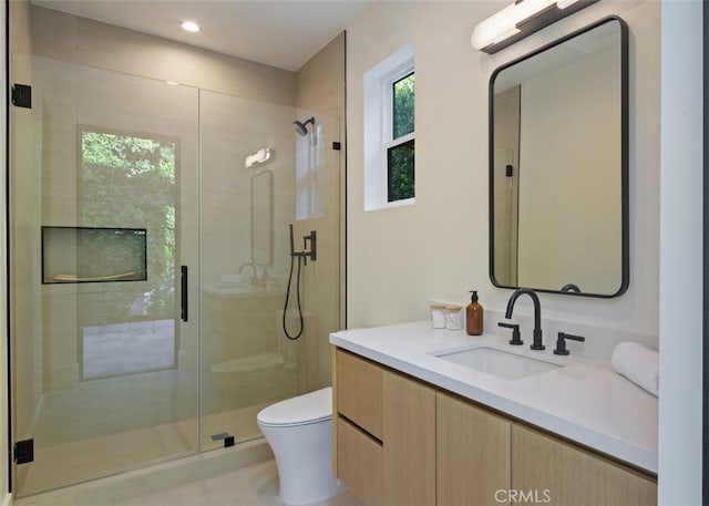 bathroom featuring vanity, toilet, and an enclosed shower