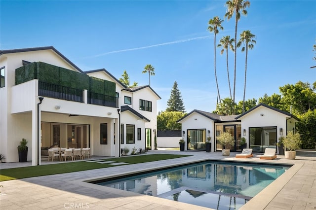 rear view of property with a patio, a balcony, and an outdoor hangout area