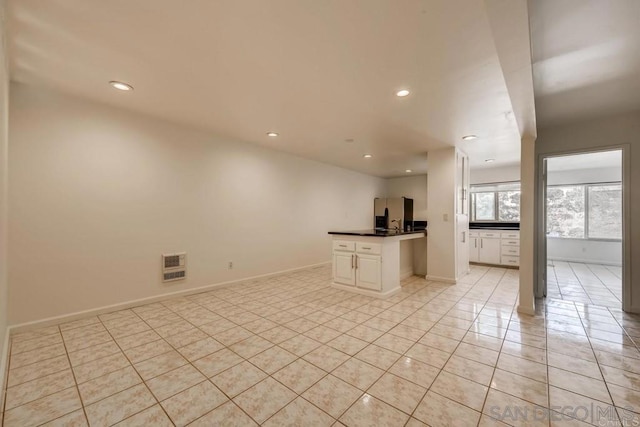 interior space featuring white cabinets and light tile patterned flooring