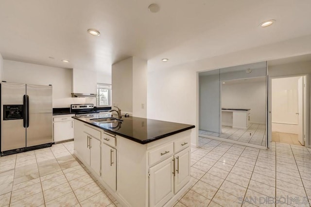 kitchen with stainless steel appliances, sink, light tile patterned floors, a center island with sink, and white cabinets