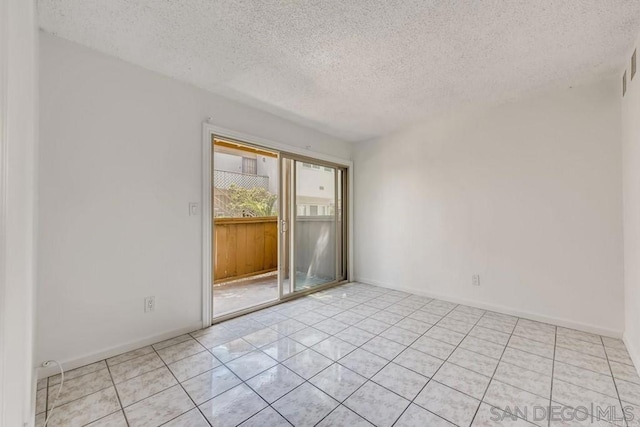 unfurnished room featuring light tile patterned floors and a textured ceiling