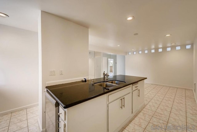 kitchen featuring sink, white cabinets, a center island with sink, and light tile patterned floors