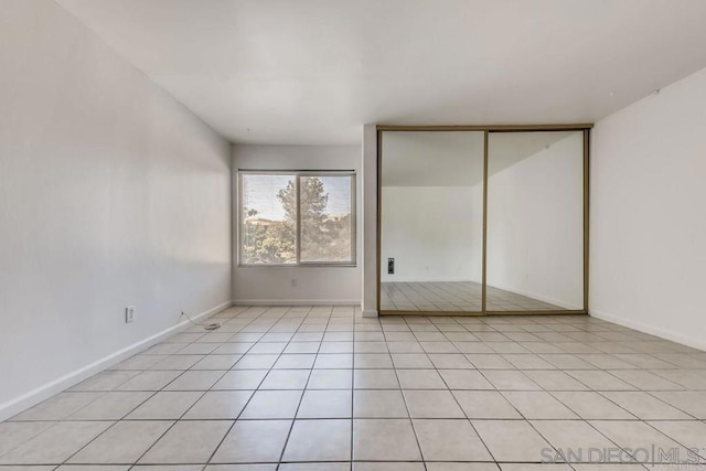 unfurnished bedroom featuring light tile patterned floors and a closet