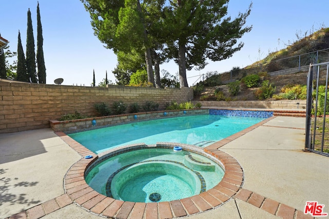 view of pool featuring an in ground hot tub