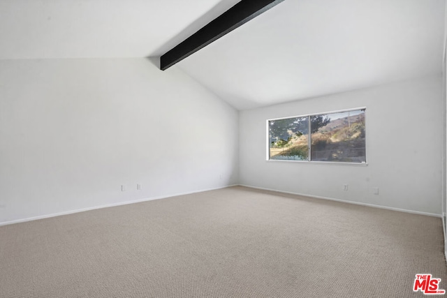 spare room featuring carpet flooring and vaulted ceiling with beams