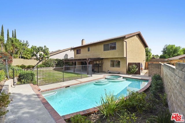 view of swimming pool featuring a lawn, an in ground hot tub, and a patio