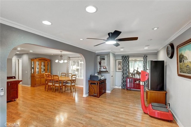 interior space featuring crown molding, ceiling fan with notable chandelier, and light hardwood / wood-style flooring