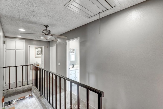 hall with carpet and a textured ceiling