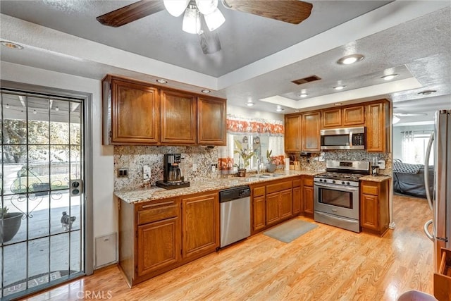 kitchen featuring appliances with stainless steel finishes, a raised ceiling, and backsplash