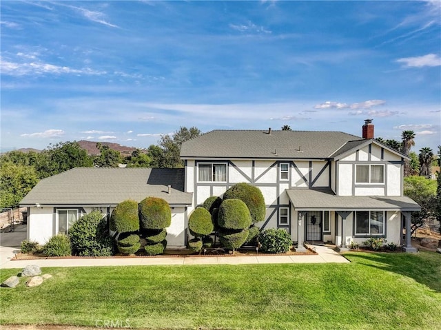 tudor-style house with a front lawn