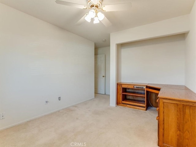 unfurnished office featuring ceiling fan and light carpet