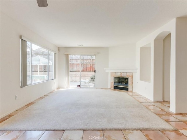 unfurnished living room featuring a tiled fireplace and light tile patterned floors