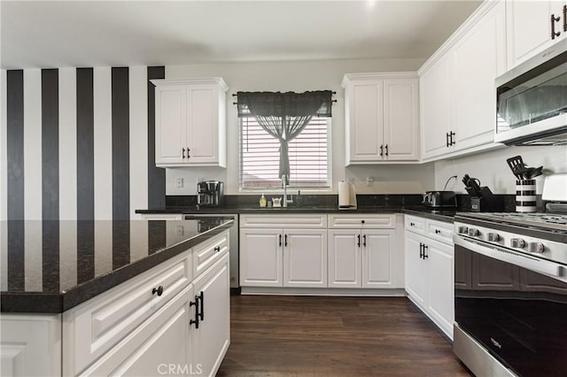 kitchen with dark hardwood / wood-style floors, sink, white cabinetry, and stainless steel appliances