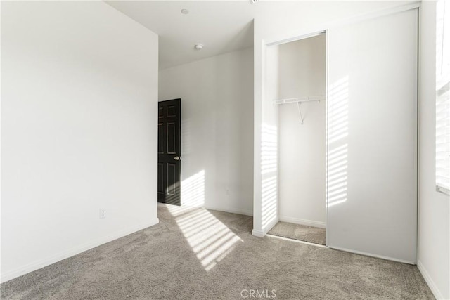 unfurnished bedroom featuring a closet and light colored carpet