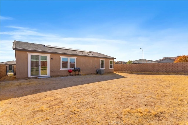 rear view of property with central AC