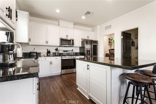 kitchen featuring stainless steel appliances, white cabinetry, dark hardwood / wood-style floors, and sink