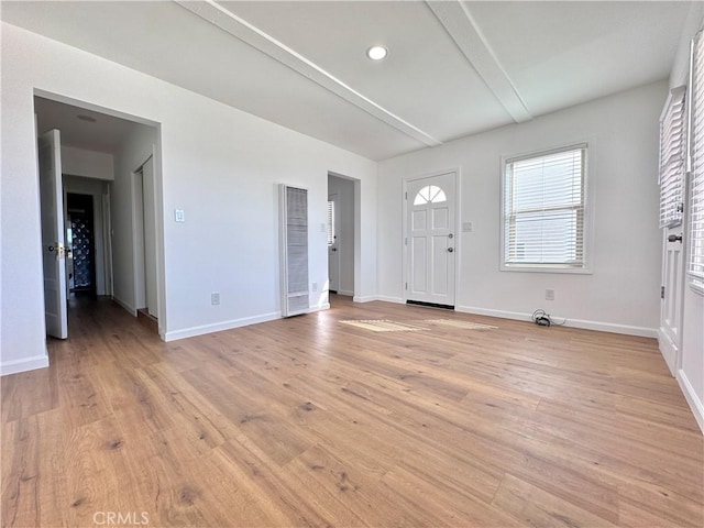 entryway featuring beamed ceiling and light hardwood / wood-style flooring