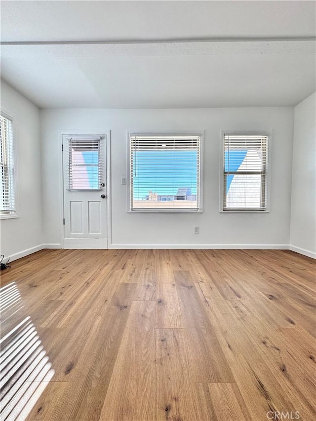 unfurnished room featuring plenty of natural light and light hardwood / wood-style floors