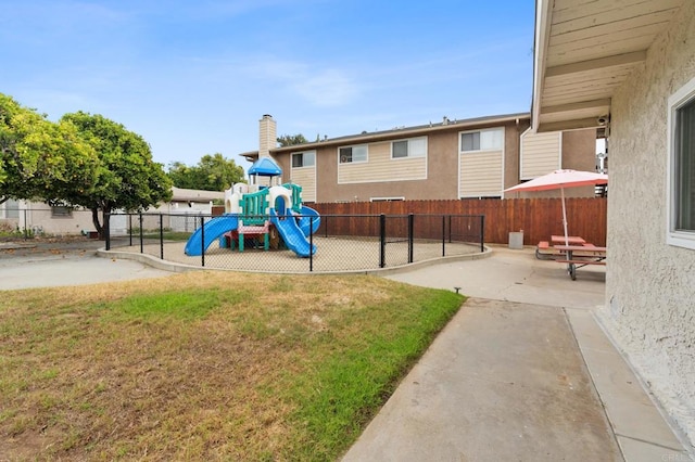 view of jungle gym with a yard and a patio