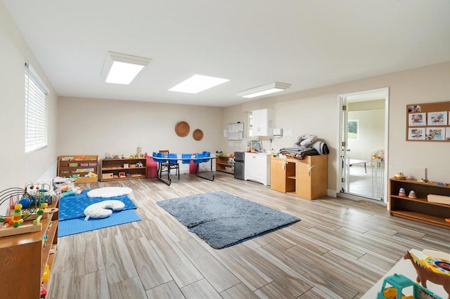 rec room featuring lofted ceiling and light hardwood / wood-style flooring