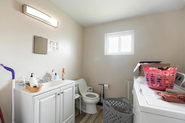 bathroom with vanity, washer and dryer, toilet, and hardwood / wood-style floors