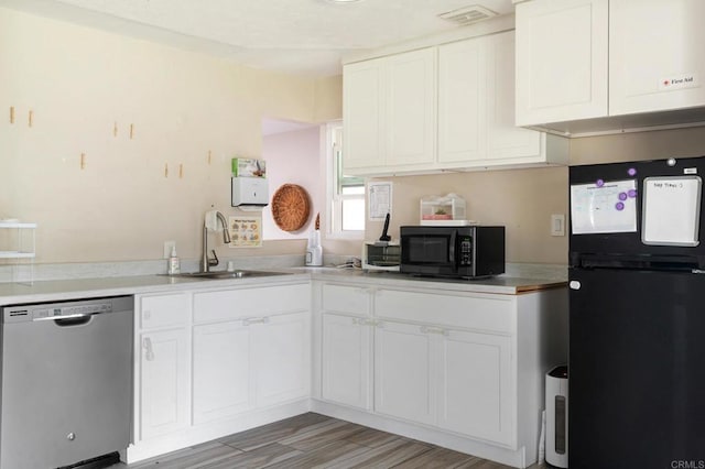 kitchen featuring sink, black appliances, white cabinets, and light wood-type flooring