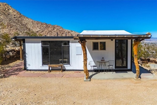 rear view of house featuring a mountain view and a patio