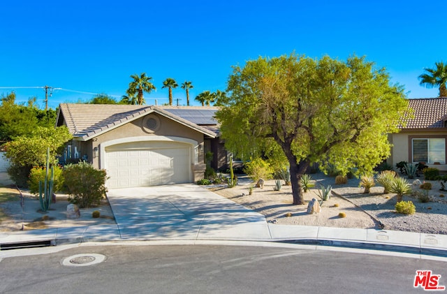 view of front of home with a garage and solar panels