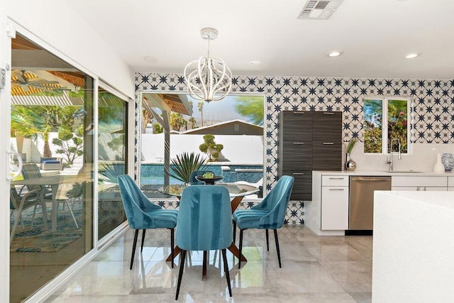 dining room featuring sink, a healthy amount of sunlight, and a chandelier