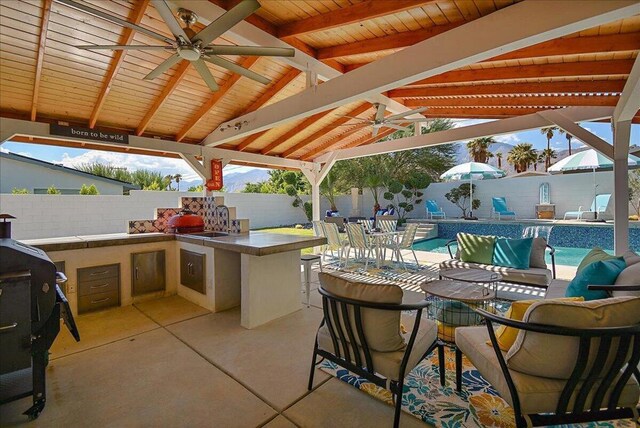 view of patio / terrace featuring a gazebo, an outdoor bar, a fenced in pool, ceiling fan, and an outdoor living space