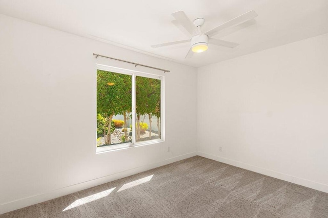 carpeted spare room featuring plenty of natural light and ceiling fan