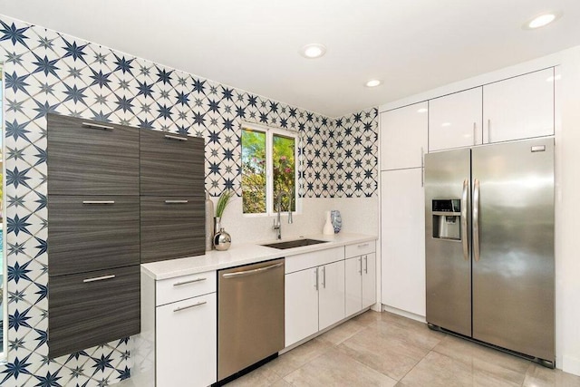 kitchen with sink, white cabinetry, light tile patterned floors, and stainless steel appliances