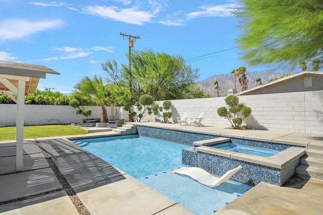 view of pool with an in ground hot tub, a patio area, and a mountain view