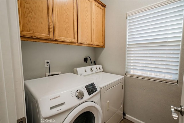 laundry room with washer and dryer and cabinets