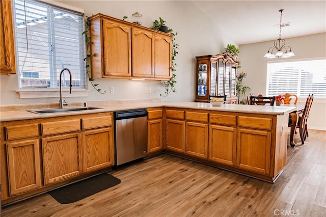 kitchen featuring sink, dishwasher, a notable chandelier, light hardwood / wood-style floors, and decorative light fixtures